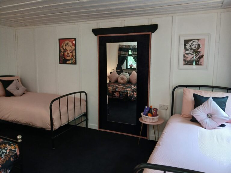 Twin bedroom with pink bedding and mirror